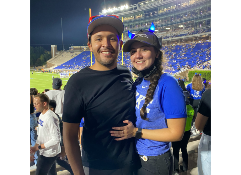 Lauren Aslanian and her boyfriend, Nick, standing together in the stands of a sports stadium.