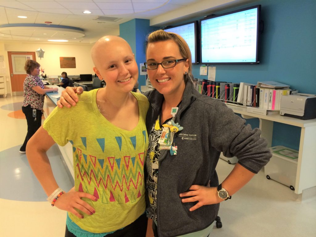 Lauren Aslanian, left, and Nurse Kim Sladek, right, stand together with smiles on their faces.