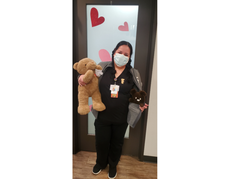 CHOC Associate Veronica in her nurse uniform hollding Choco Bear stuffed toys