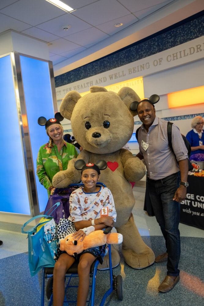 CHOC patient family posing with Choco Bear, the hospital's mascot 
