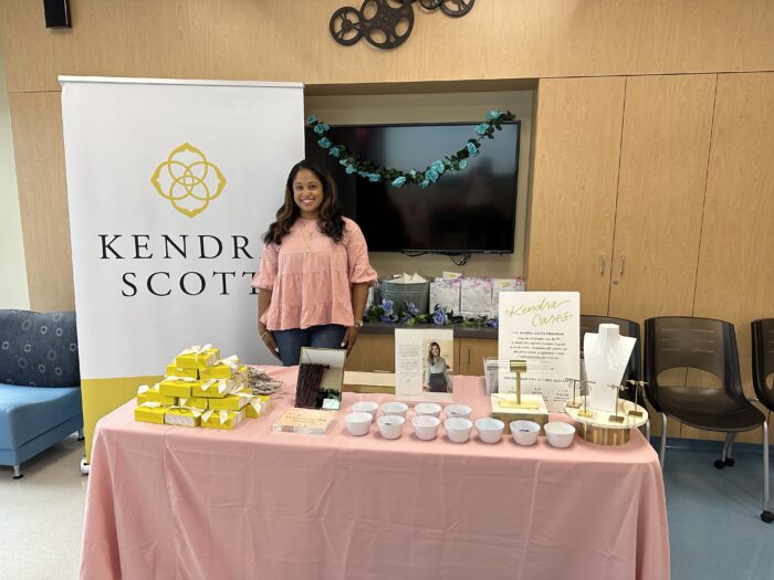 a table with a pink tablecloth featuring kendra scott's cause marketing campaign.