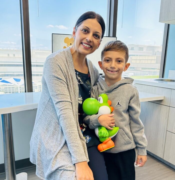 Dr. Nita Doshi with CHOC patient Ethan, who is holding a Yoshi dinosaur toy. 