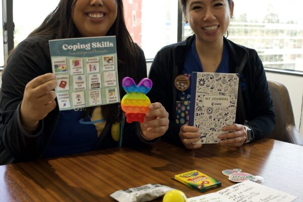 CHOC specialists holding up items from the mental health coping kits.