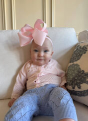Dylan, pictured with a big pink bow on her head, smiling