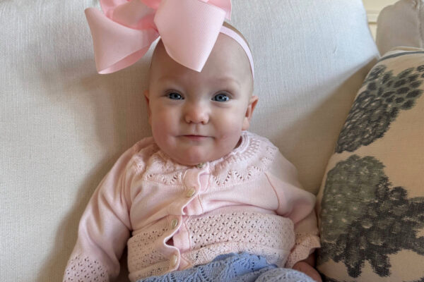 Dylan, pictured with a big pink bow on her head, smiling