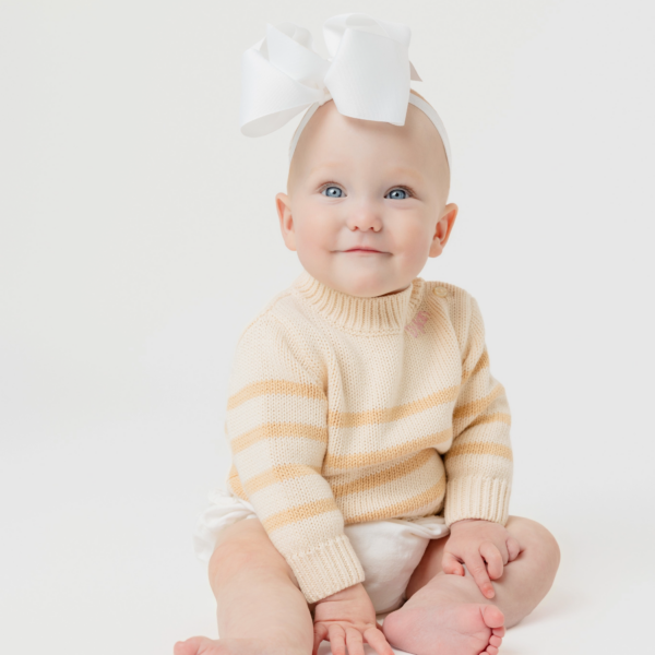 Dylan, pictured with a big bow on her head, smiling
