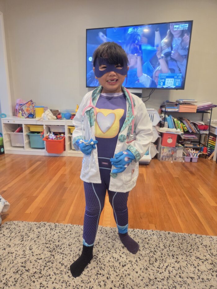 Kali wearing her nurse and superhero costume.